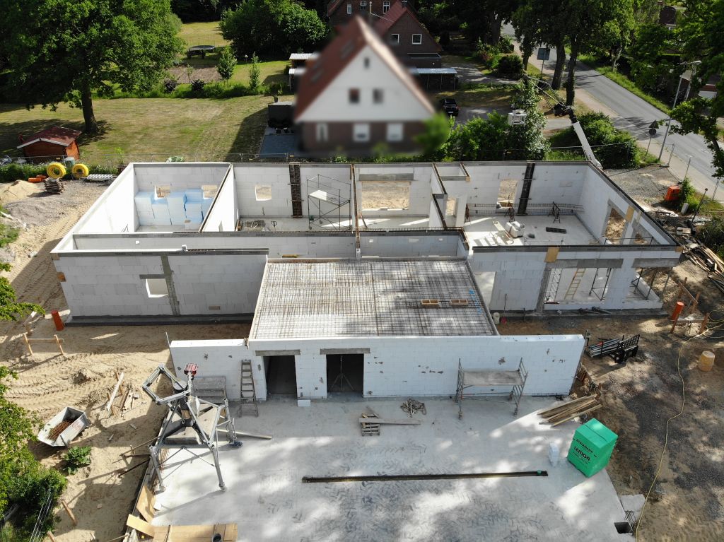 Auf diesem Foto ist das neue Feuerwehrgerätehaus Otternhagen in der Seitenansicht abgebildet. Eine Seitenwand der zukünftigen Fahrzeughalle befindet sich bereits im Aufbau. Die Arbeiten an der Gebäudedecke des Verbindungsbauwerkes sind deutlich sichtbar.