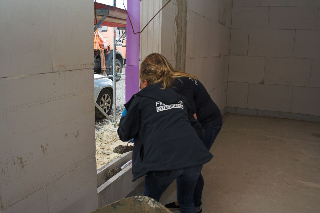 Auf dem Foto wird gezeigt, das Jede/r Anwesende die Gelegenheit bekam, selbst beim einbetonieren des "Grundsteins" zu helfen - und somit beim Bau des neuen Gerätehauses mitzuwirken.