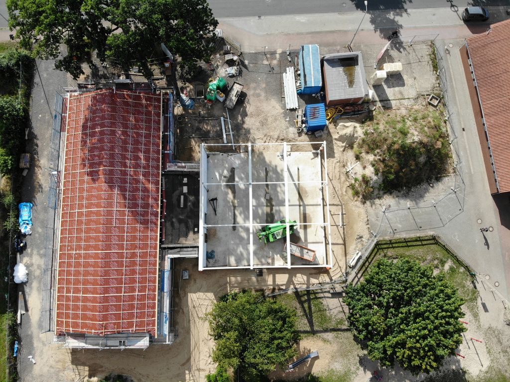 Das Bild zeigt das neue Feuerwehrgerätehaus Otternhagen aus der Vogelperspektive. Deutlich sichtbar: Für jeden Fahrzeug-Stellplatz wurde im Hallenboden bereits eine Ablaufrinne für anfallendes Wasser eingearbeitet.