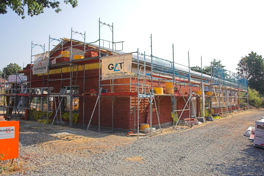 Das Foto zeigt eine Frontansicht des Dienstgebäudes: Auch in diesem Bereich sind die Arbeiten an der Klinkerfassade weit vorangeschritten.