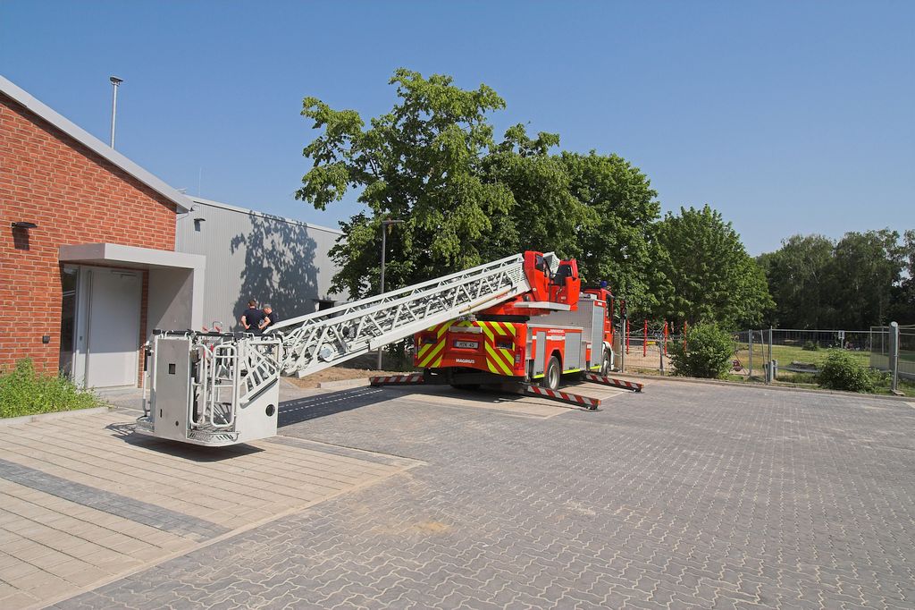 Das Foto zeigt, wie die DLK32/12 auf dem Parkplatz hinter dem Feuerwehrgerätehaus aufgestellt wird.
