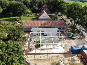 Diese Aufnahme zeigt die Fahrzeughalle in der Seitenansicht. Der linke Zugang im Verbindungsbauwerk führt in das Dienstgebäude und wurde verschlossen. Über den rechten Durchgang wird Raum für Reinigungs- und Pflegearbeiten erreicht.